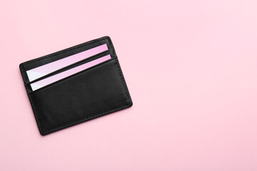 Leather business card holder with blank cards on pink background, top view. Space for text