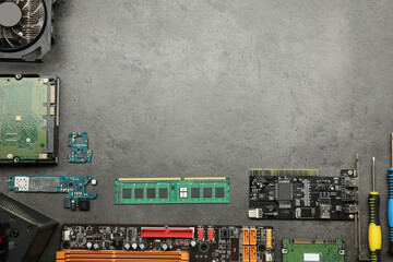 Graphics card and other computer hardware on grey textured table, flat lay. Space for text