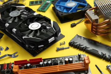 Graphics card and other computer hardware on yellow background, closeup