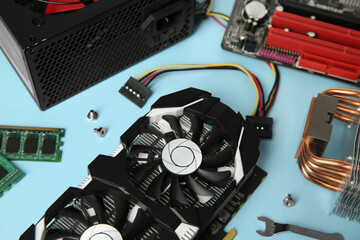 Graphics card and other computer hardware on light blue background, closeup