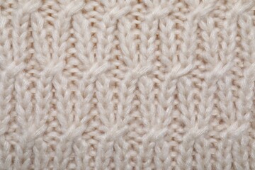 Beige knitted scarf as background, top view