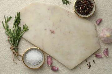 Cutting board, salt, pepper, rosemary and garlic on white textured table, flat lay. Space for text