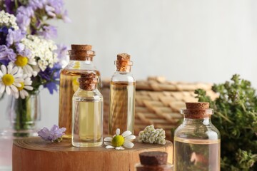 Aromatherapy. Different essential oils and flowers on against light background