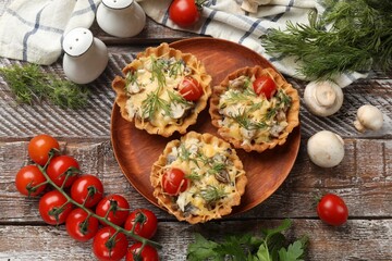 Tasty tartlets with cheese, tomatoes, mushrooms and dill among ingredients on wooden rustic table, flat lay