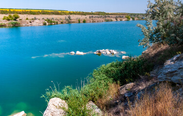 View of the flooded granite quarry with turquoise clear water