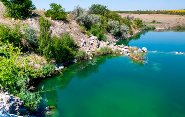 View of the flooded granite quarry with turquoise clear water, Ukraine