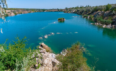 View of the flooded granite quarry with turquoise clear water, Ukraine