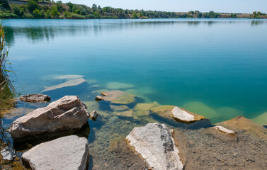 View of the flooded granite quarry with turquoise clear water, Ukraine