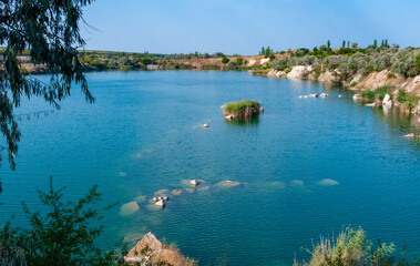 View of the flooded granite quarry with turquoise clear water, Ukraine