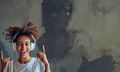 Cheerful individual with headphones on, smiling widely and gesturing towards the headphones
