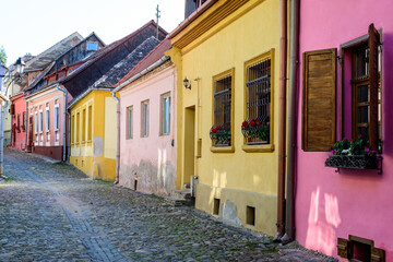 Old colorful painted houses in the historical center of the Sighisoara citadel, in Transylvania (Transilvania) region of Romania, in a sunny summer day.