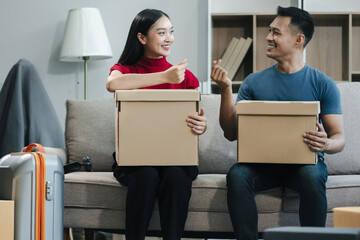 young couple helps put things in boxes and prepares, smiling happy moving to a new house.