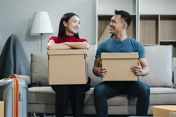 young couple helps put things in boxes and prepares, smiling happy moving to a new house.