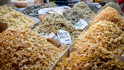 various anchovies displayed at traditional market. various kinds of dried anchovies and shrimps in containers for sale at traditional markets. 