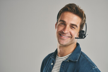 Man, portrait and headset for call centre for customer service on grey background, contact us or...