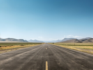 Fototapeta premium An unoccupied road cuts through a scenic landscape under a clear sky