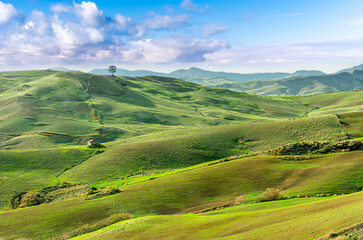 green spring season landscape of beautiful grassland hills in countryside with villages and...