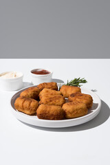 Plato de croquetas fritas con salsa de tomate y mayonesa aperitivo sobre fondo gris