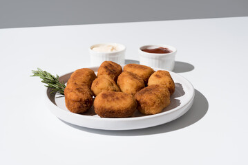 Plato de croquetas fritas con salsa de tomate y mayonesa aperitivo sobre fondo gris