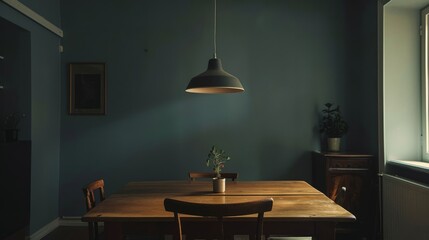 A dining room with a wooden table,  simple chairs,  and a single pendant light