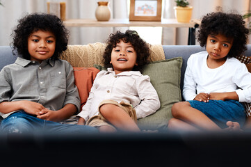 Children, couch and watching tv or home relax for morning cartoon or streaming, subscription or...