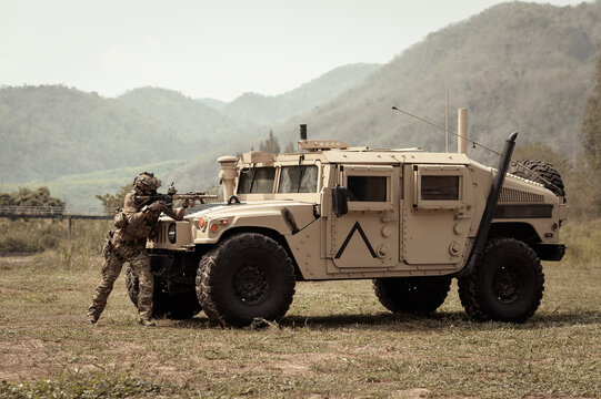 United States Army in camouflage uniforms operation in the forest.with armored vehicle, soldiers training  in a military operation