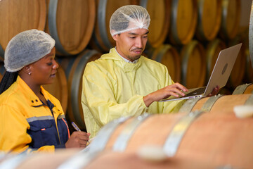 Professional winemaker controlling wine making process and quality at winery factory