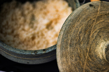 Shallow focus closeup of a earthenware container of steamed rice