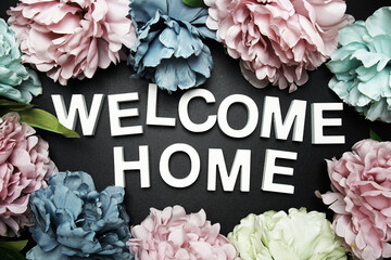Welcome Home alphabet letter with flower decoration on black background