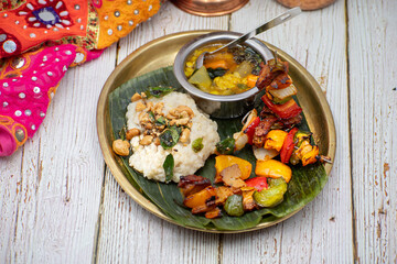 Air fried vegan barbeque  seitan and vegetables skewers served on banana leaf along with Indian pongal and sambar