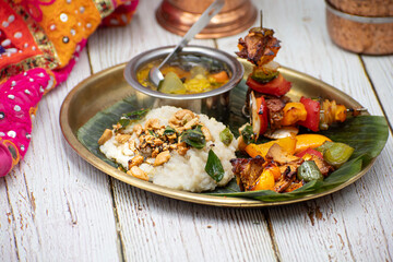 Air fried vegan barbeque  seitan and vegetables skewers served on banana leaf along with Indian pongal and sambar