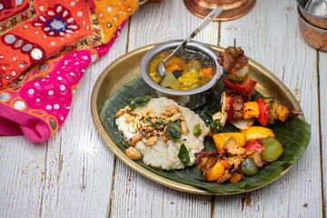 Air fried vegan barbeque  seitan and vegetables skewers served on banana leaf along with Indian pongal and sambar
