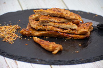 Vegan seitan schitzel slices on slate plate, cut steak style