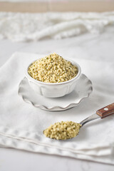 Shelled hemp seeds in a bowl with spoon