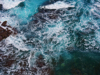Aerial photo of a sea water surface. Turquoise water with foam on waves - view from above. Water...