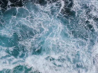 Aerial photo of a sea water surface. Turquoise blue water with white foam on waves - view from...