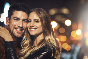Smile, portrait and couple in city at night with bokeh for romantic date together for bonding....