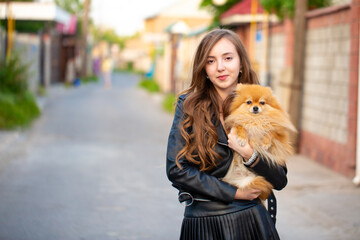 Beautiful young girl with a dog in her arms. Love to the animals. Pet on a walk. Animal protection....