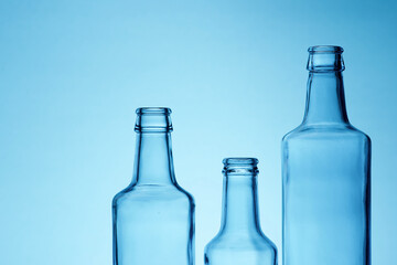 Blue empty glass water bottles and blue white background