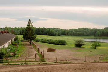a landscape with a stable, a forest and a river