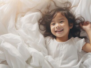 Resting on a white bed, adorable Asian children exude charm and innocence