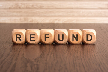 the text 'refund' is written on wooden cubes on a brown background