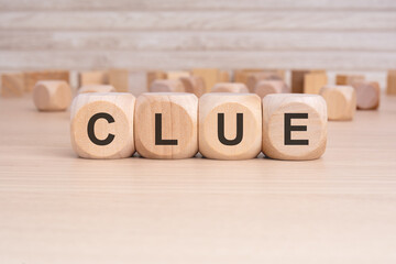 the text Clue is written on wooden cubes on a brown background