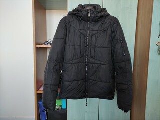 Dark winter jacket hanging on a hanger on closet door