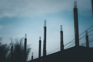 A construction site with a lot of scaffolding and a lot of wires. The sky is blue and the sun is shining