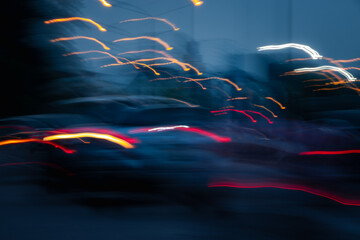 A blurry image of cars on a road with a blue sky in the background. The cars are moving fast and...