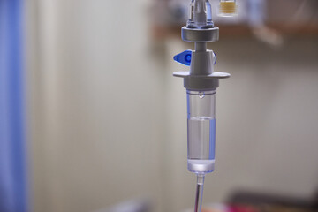 Close-up of slow iv fluid intravenous drip saline with blurred background in a hospital room, medical concept with copy space