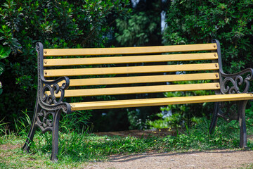 Iron frame park bench with garden background.