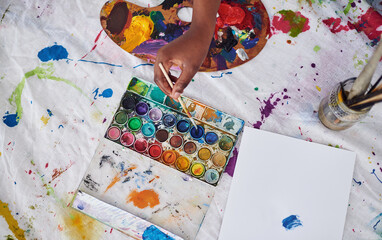 Fototapeta premium Paintbrushes, artist and hands for palette in studio, color and craft in small business and shop. Workshop, equipment and supplies for person, container and project, art and painting in store