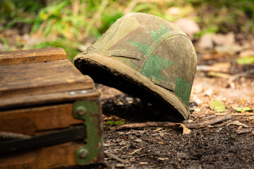 WWII german helmet on the ground. Wehrmacht m35 ( stahlhelm ) helmet in cover. Camouflage type Splinter ( splittertarnmuster )